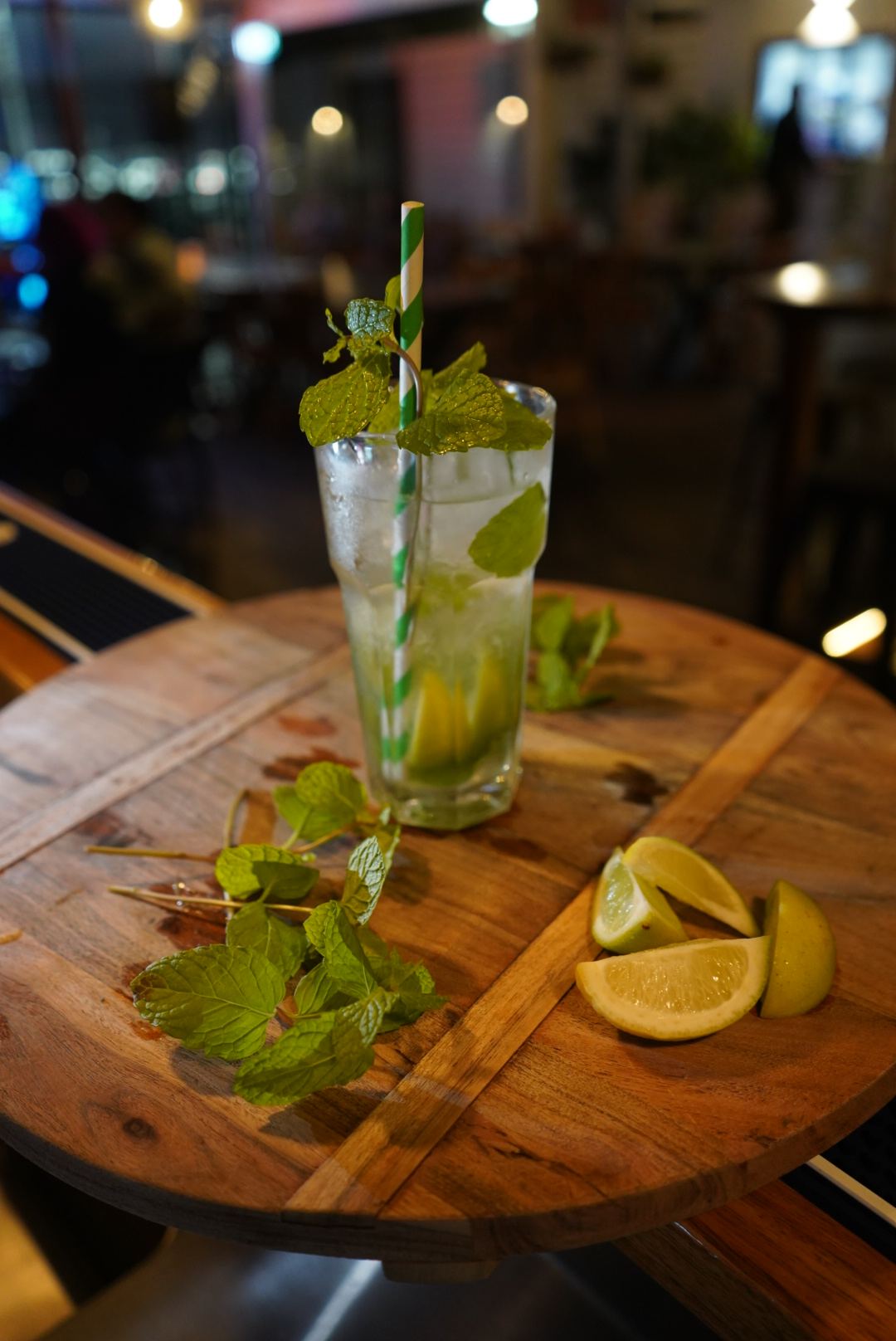 A fresh mojito with mint and lime on a wooden table at the bar