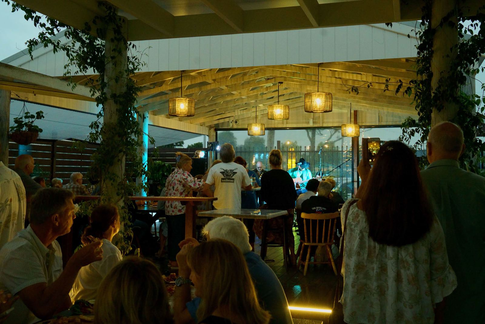 The Terrace at night, with guests gathered under festoon lights for live music